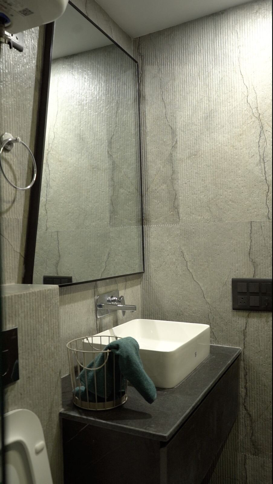 Samsara Residence bathroom vanity with textured stone walls